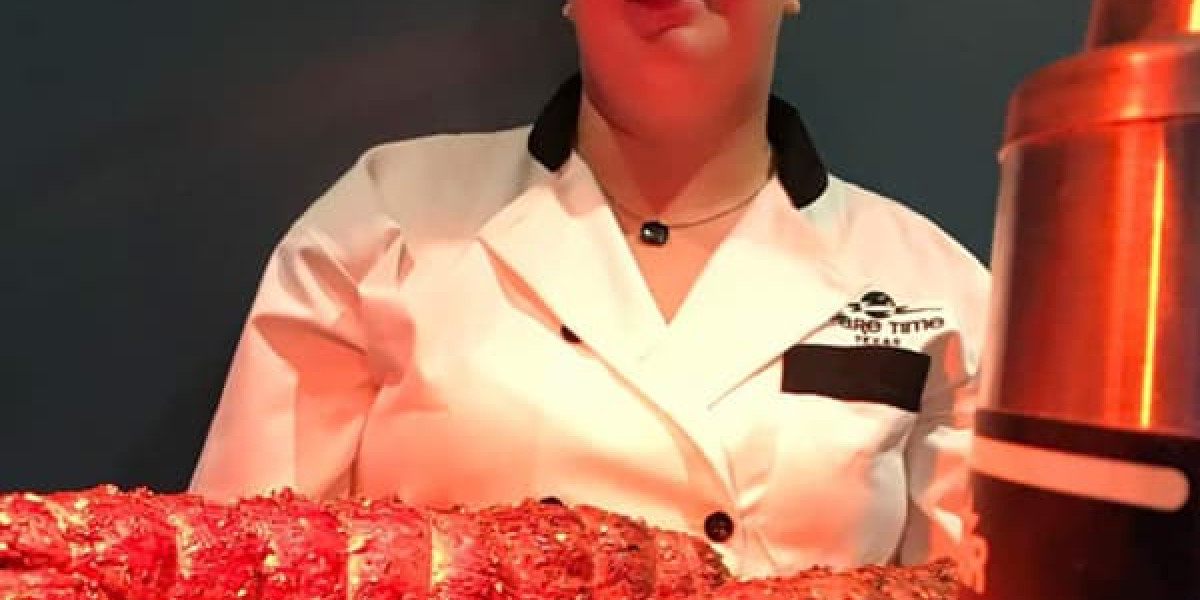 A person in a white uniform stands behind a table with a large cooked lobster at Spare Time Texas, where the dimly lit background adds an air of mystery. A metallic container is visible on the right side, offering a unique dining experience at this family fun center.
