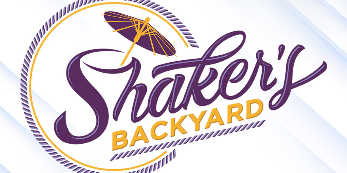 Logo of "Shaker's Backyard," a family fun center, featuring stylized purple text with a yellow parasol above. The word "BACKYARD" in bold yellow text below is set inside a circular outline, evoking the lively spirit of Spare Time Texas.