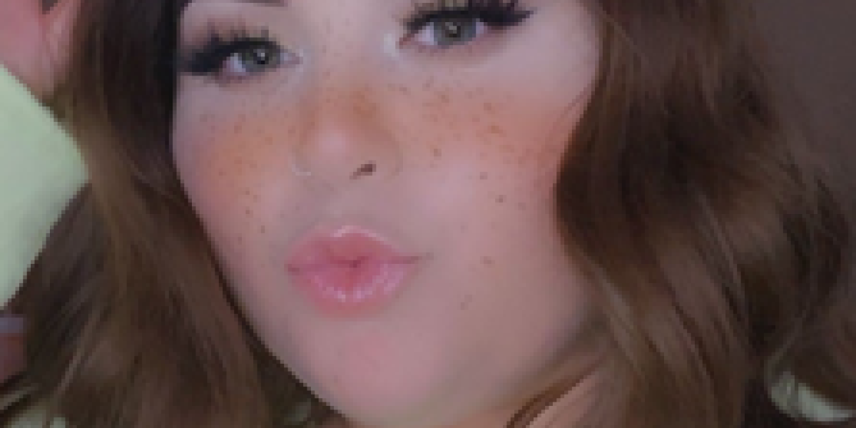 A person with long brown hair and freckles poses for a selfie, capturing their light makeup of mascara and lip gloss. Wearing a light-colored top, they’re all smiles after enjoying some bowling in Spare Time Texas. The background is softly blurred, adding to the serene vibe.