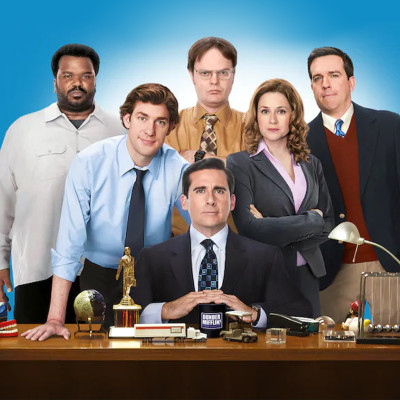 A group of six office workers stands confidently, as if ready for a team outing to a family fun center. A man sits at a desk holding a mug, surrounded by office items, while four men and one woman pose behind him against a blue background, dressed in business attire reminiscent of a Spare Time Texas event.