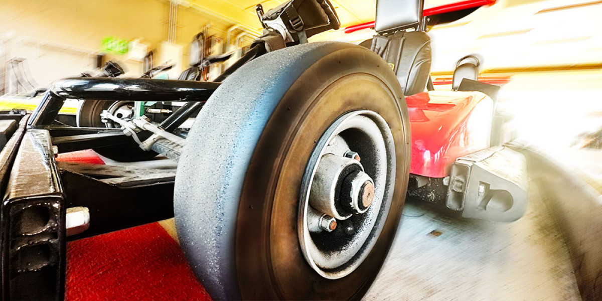 Close-up of a vibrant go-kart wheel and its sleek frame, prominently featuring a red body at Spare Time Texas. The background is a blurred indoor track, suggesting fast motion and an exhilarating racing atmosphere in this lively family fun center.