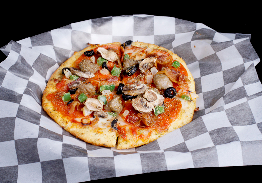 A freshly baked pizza on checkered paper, topped with pepperoni, mushrooms, green bell peppers, olives, and sausage, sits invitingly against a black background. Perfect for a night at Spare Time Texas where bowling and delicious food make for unforgettable family fun.
