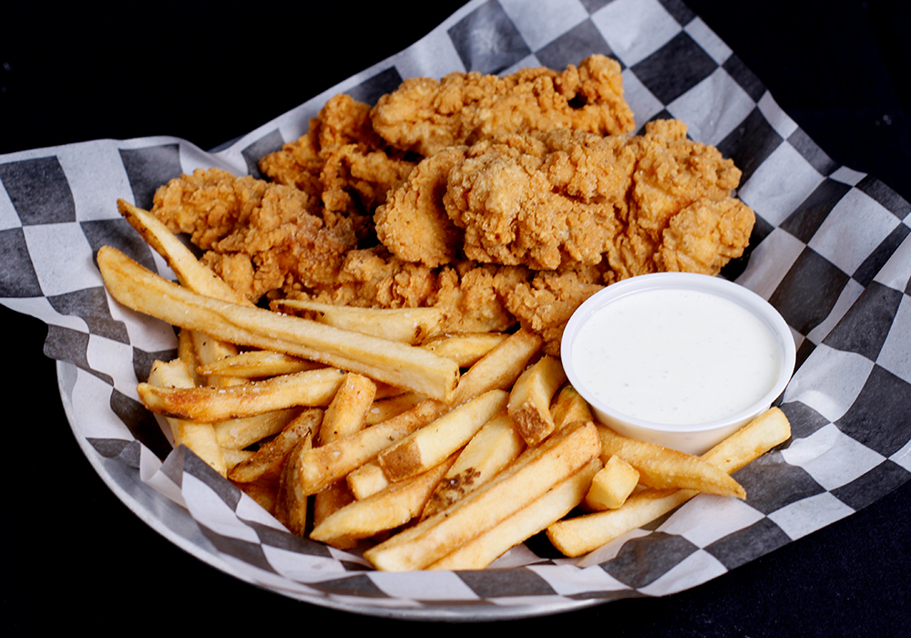 At Spare Time Texas, enjoy a plate of crispy fried chicken tenders and golden French fries served on checkered paper, perfect after a round of bowling. Accompanied by a small cup of creamy dipping sauce, it’s the ideal treat at this family fun center.