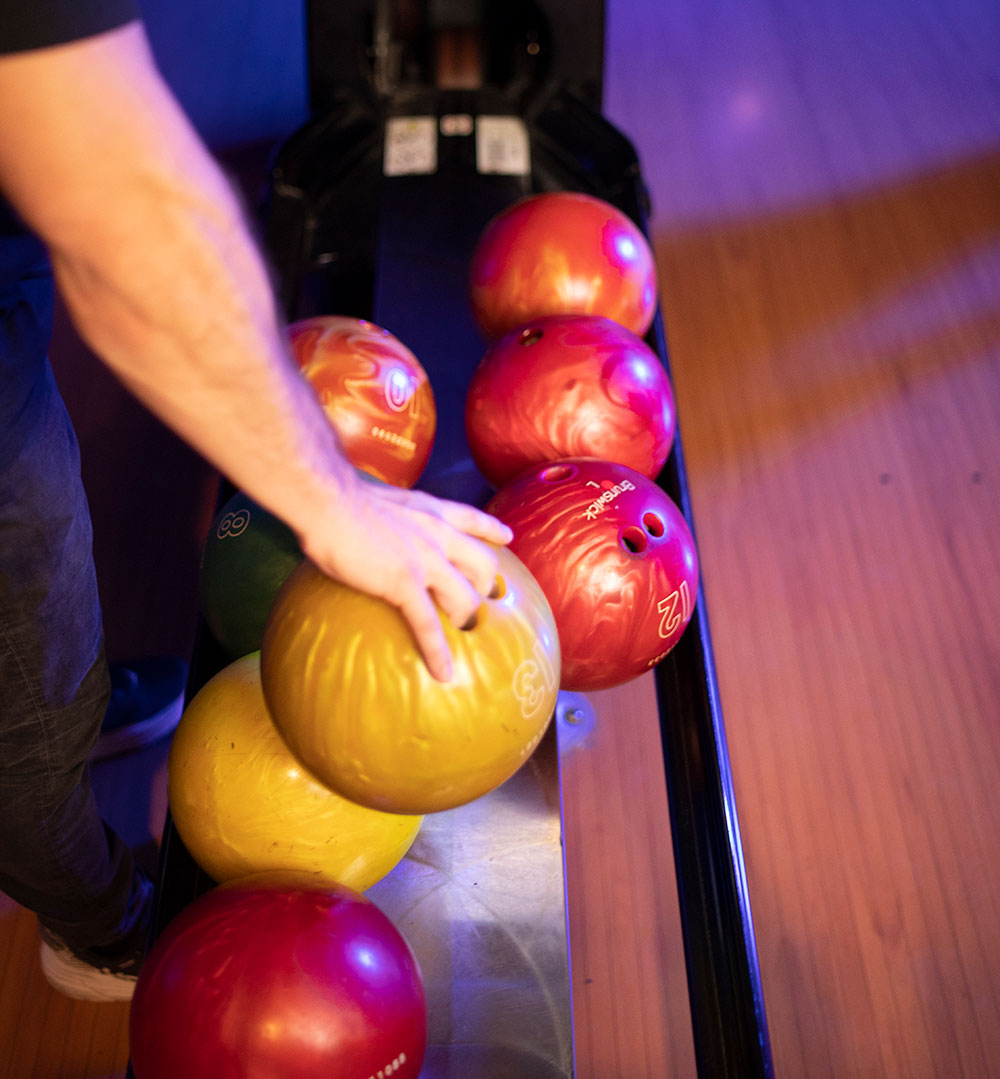 Man's Hand Choosing a Bowling Ball